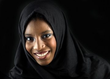 Smiling muslim teenage girl posing on black background  (this picture has been taken with a Hasselblad H3D II 31 megapixels camera)